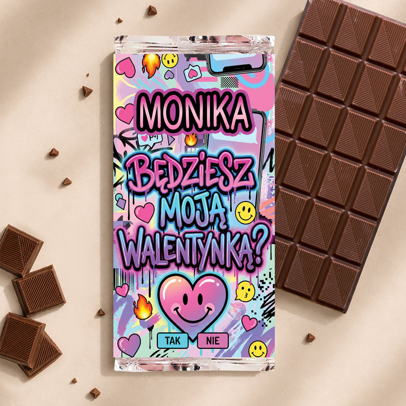 Kolorowy projekt z napisem "MONIKA" oraz pytaniem "Będziesz moją walentynką?" na tle serc, emoji i ognia, obok tabliczka czekolady.