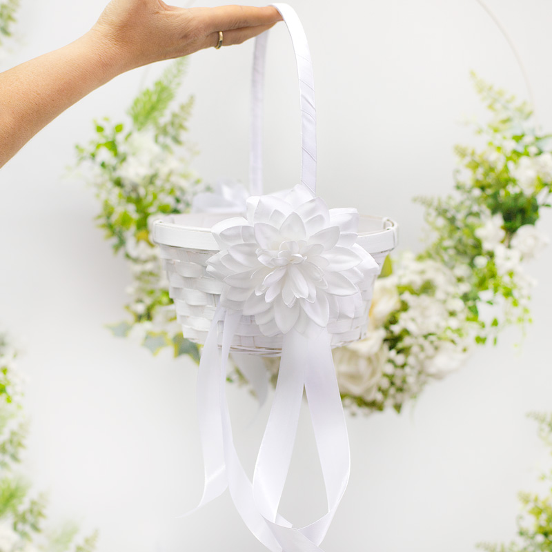 Koszyk wiklinowy dekoracyjny w białym kolorze z dodatkiem białego kwiatka i wstążek.