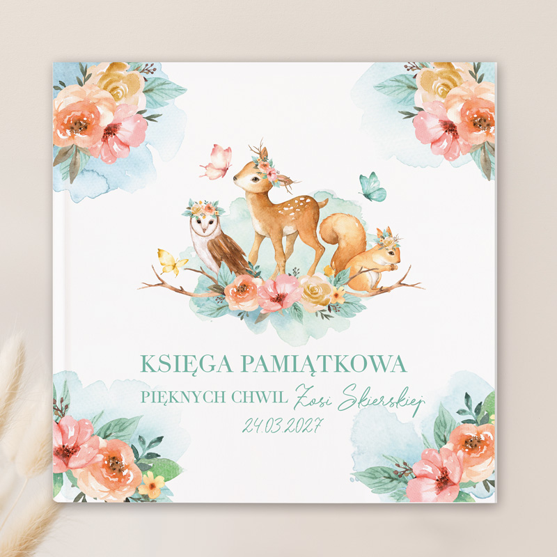 Ilustracja księgi pamiątkowej z leśnymi zwierzętami, takimi jak sarenka, sowa i wiewiórka, otoczonymi kwiatami w pastelowych kolorach oraz napisem "KSIĘGA PAMIĄTKOWA PIĘKNYCH CHWIL