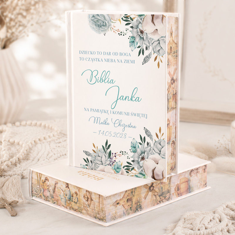 Biblia z kwiatowymi motywami, ozdobiona tekstem: "Dziecko to dar od Boga...", z datą i imieniem na pamiątkę komunii.
