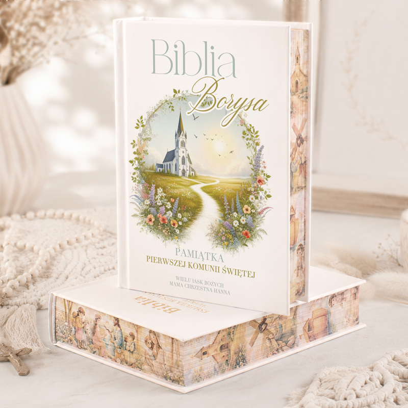 Biblia Borysa z ilustracją kościoła oraz ścieżką, z napisem "Pamiątka Pierwszej Komunii Świętej".