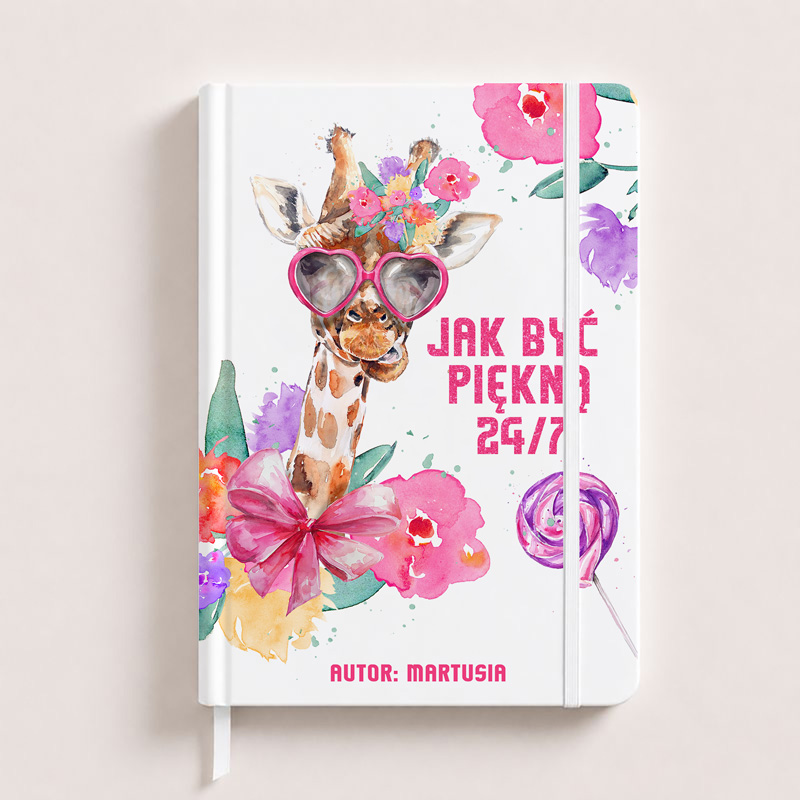 Notatnik z kolorową okładką przedstawiającą żyrafę w okularach przeciwsłonecznych, ozdobioną kwiatami i kokardą. Na okładce napis „JAK BYĆ PIĘKNA 24/7” i autor „MARTUSIA”.
