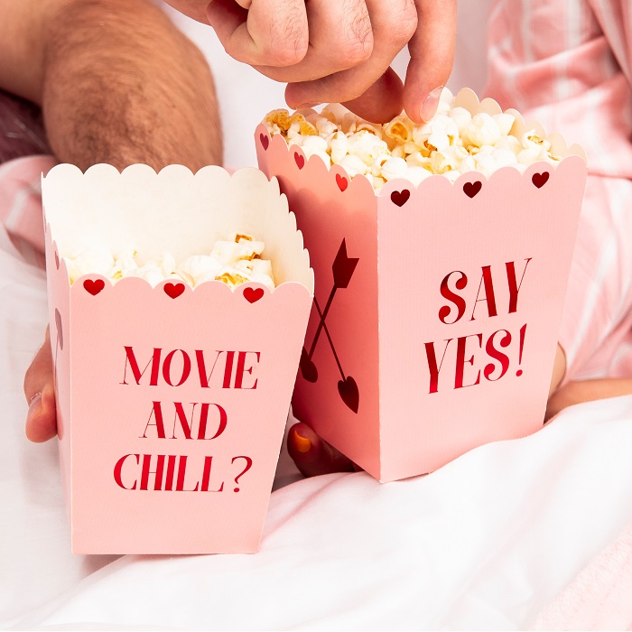 pudełka w kolorze różowym na popcorn z apisem Say yes i Movie and chili? idealne na wieczór we dwoje na Walentynki