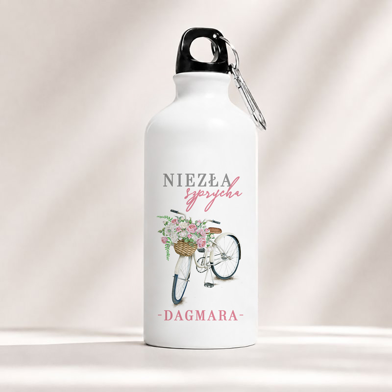 Bidon w białym kolorze z nadrukiem roweru oraz kosza pełnego kwiatów, z napisem "Niezła sprycha" i imieniem "Dagmara".