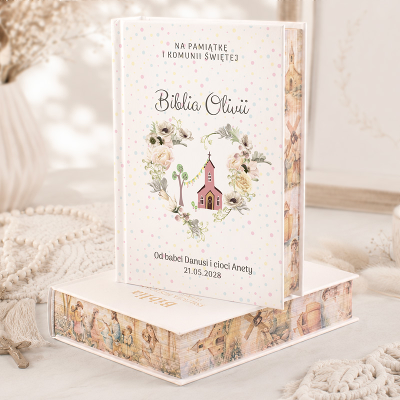 Elegancka Biblia z piękną okładką w pastelowych kolorach, ozdobiona motywem kwiatowym i małym kościółkiem.