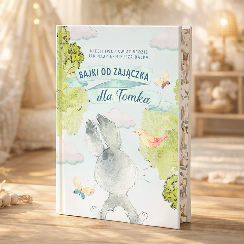 Ilustrowana książka "Bajki od zajączka dla Tomka", z rysunkiem zająca i motylami w otoczeniu przyrody.