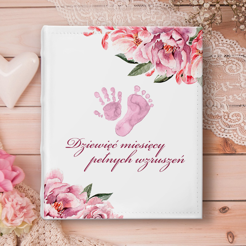 Personalizowany album na zdjęcia z motywem dziecięcych stopek na okładce, różowych kwiatów oraz imionami przyszłych rodziców.