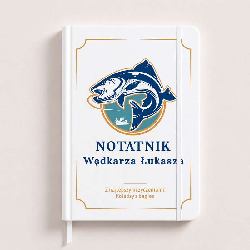 Biały notes z niebieską grafiką przedstawiającą rybę i napisem "NOTATNIK Wędkarza Łukasza" na okładce.