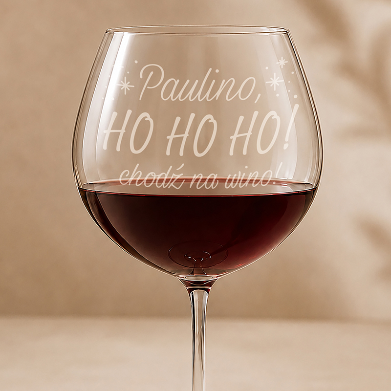 Wielka szklanka do wina z napisem "Paulino, HO HO HO! chodź na wino!" w tle wypełniona czerwonym winem.