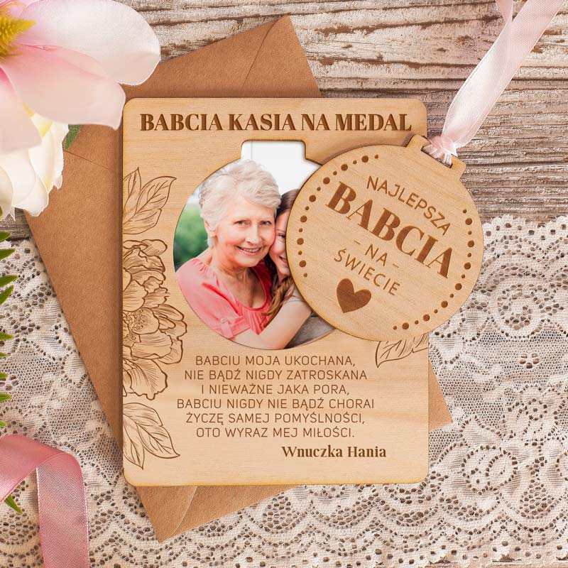 Drewniana tabliczka z grawerowanymi życzeniami dla babci, ze zdjęciem oraz wyciąganym medalem.