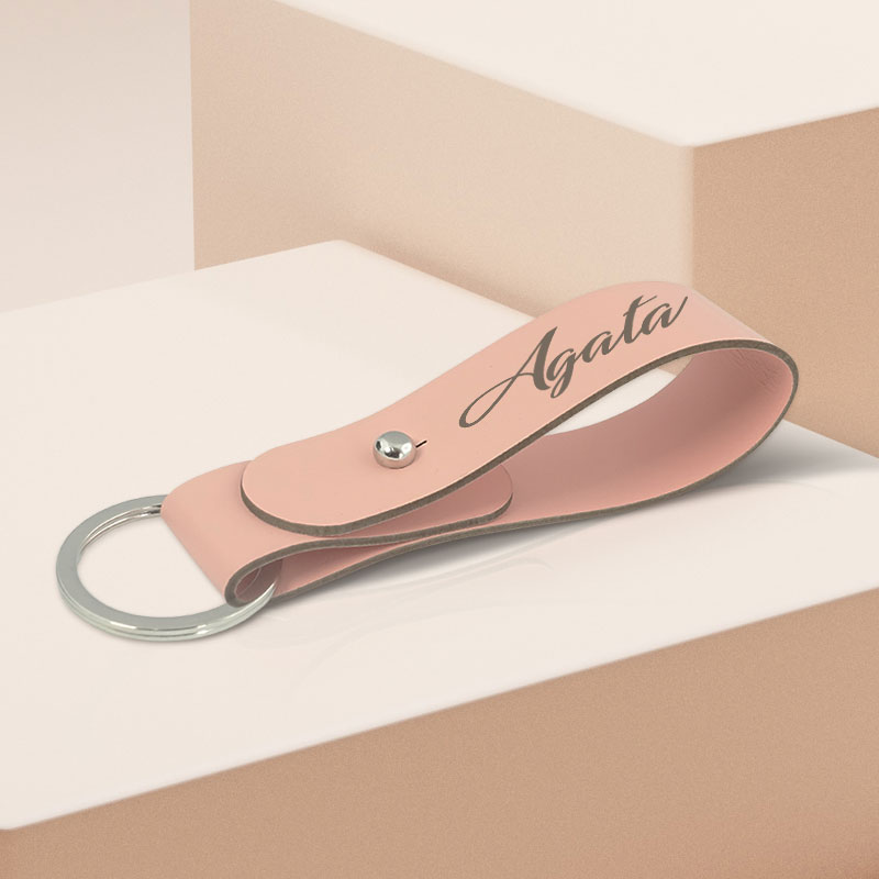 Personalizowany skórzany brelok z imieniem do kluczy, w postaci różowego paska na kółeczku z wygrawerowanym imieniem.