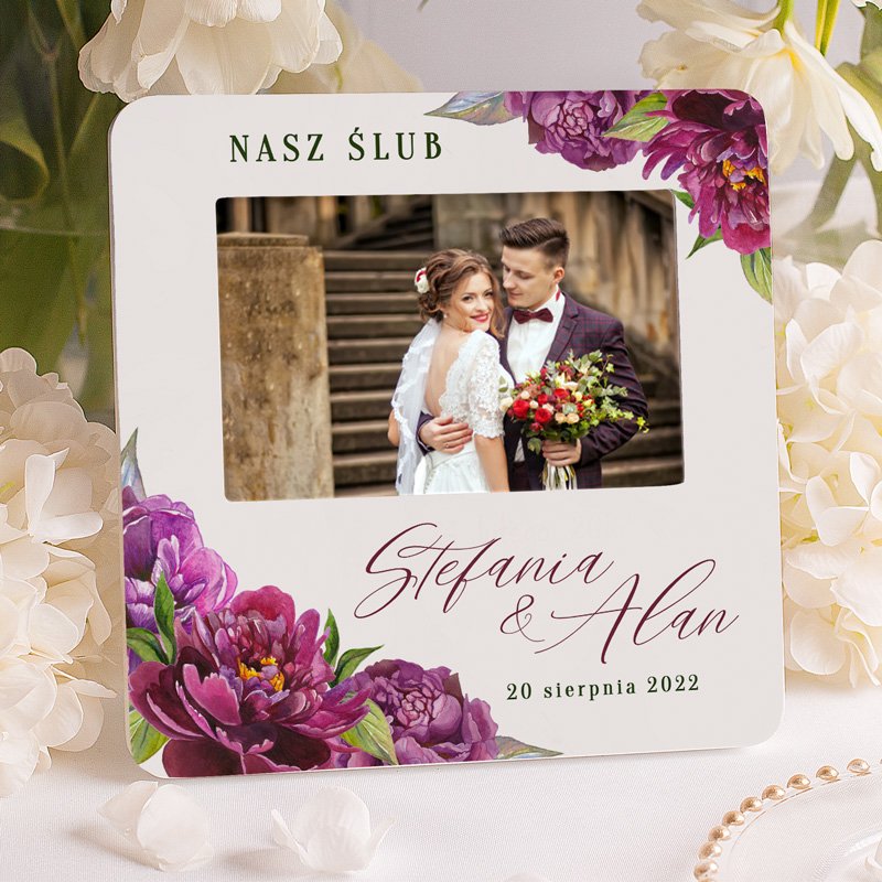 Ramka na zdjęcie nowożeńców w białym kolorze. Wzbogacona o motyw graficzny piwonii w kolorze fioletu.