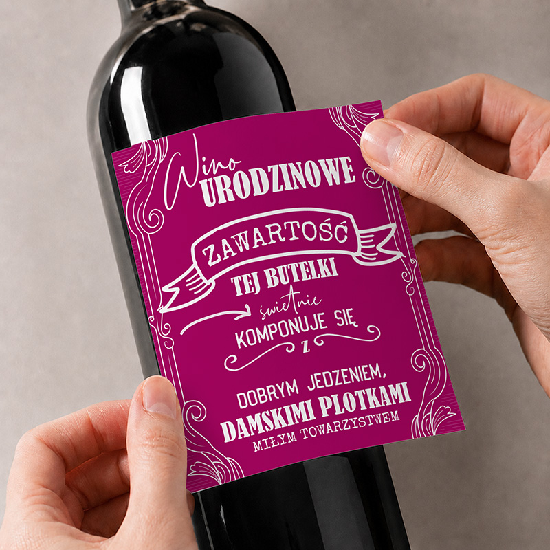 Czerwone wino z etykietą zawierającą życzenia urodzinowe i sugestie dotyczące towarzystwa przy degustacji.