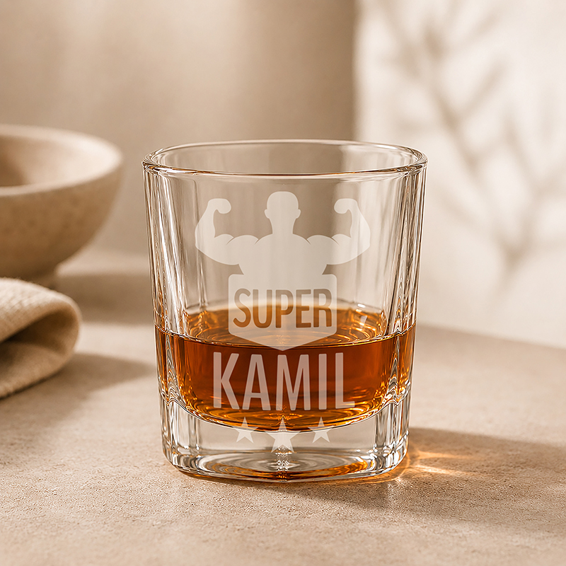 Szklanka z wytrawnym napojem, z wygrawerowanym napisem "SUPER KAMIL" i sylwetką mięśniaka w tle.