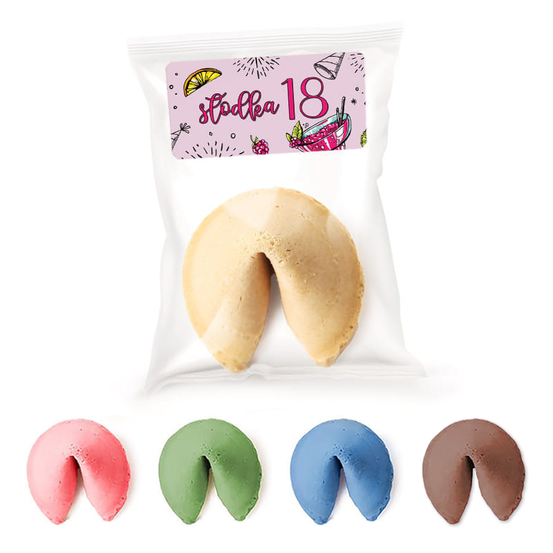 Paczka z ciastkiem szczęścia w kolorze kremowym, z etykietą 'słodka 18', otoczona ciastkami w czterech kolorach: różowym, zielonym, niebieskim i brązowym, na białym tle.