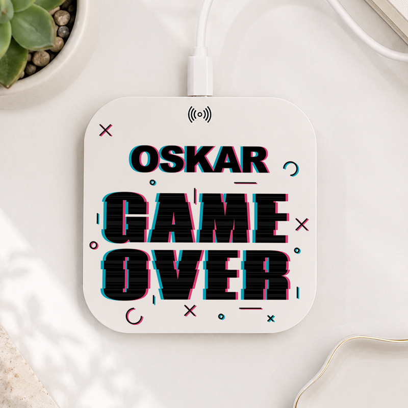 Podkładka pod mysz z napisem "OSKAR GAME OVER" w stylu retro, z geometrycznymi wzorami i przewodem podłączonym do zasilania.