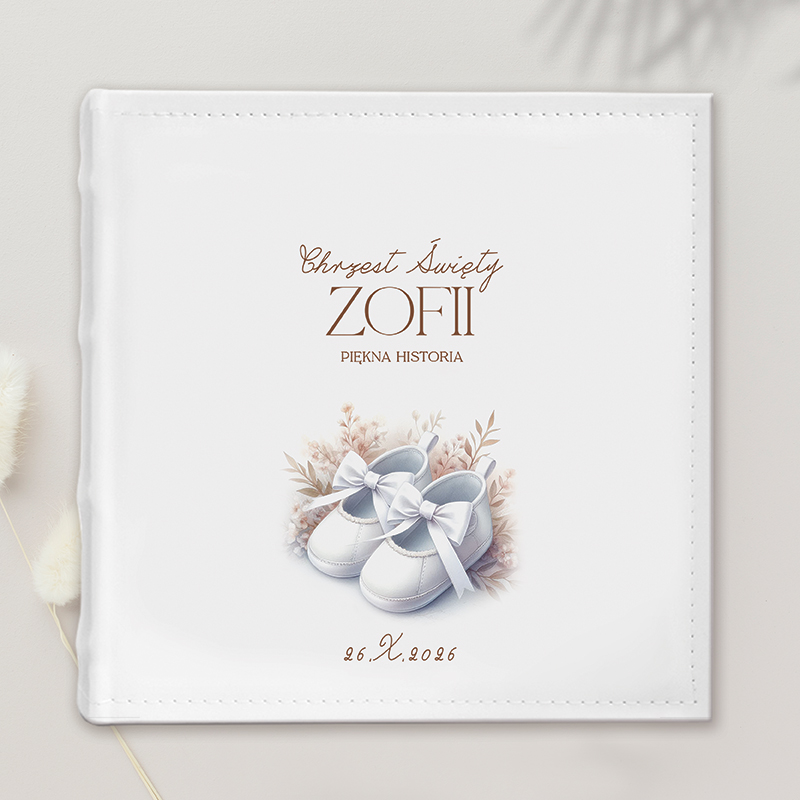 Okładka albumu na chrzest, z białymi bucikami i ozdobnymi gałązkami, z napisem "Chrzest Święty ZOFII Piękna Historia" i datą "26.X.2026".