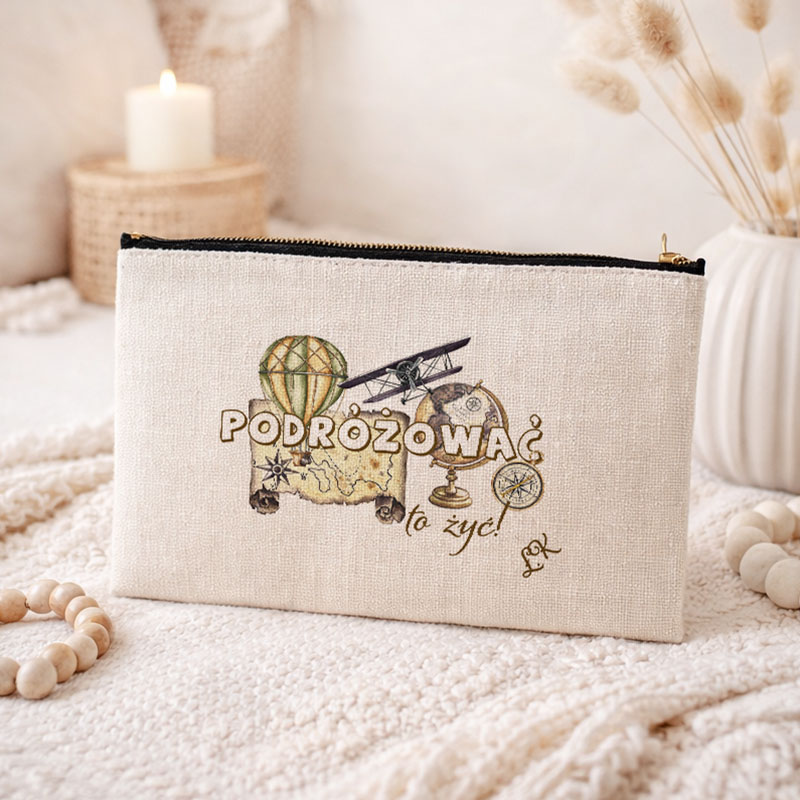 Kosmetyczka w jasnym kolorze z napisem "PODRÓŻOWAĆ to żyć", przedstawiająca mapę, balon i samolot.