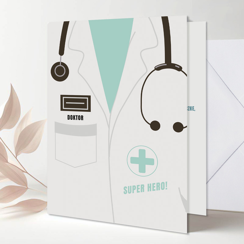 Kartka z rysunkiem białego fartucha lekarskiego, stetoskopu oraz napisem „SUPER HERO!” na tle jasnym, z dodatkowymi detalami jak imię „DOKTOR” i znak krzyża.