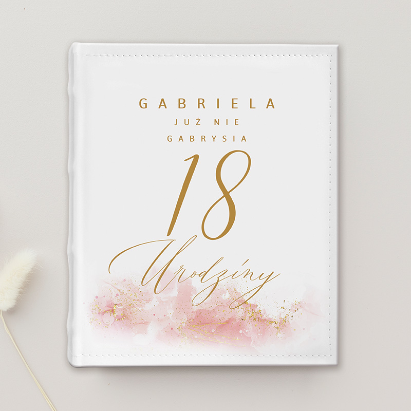 Zaproszenie na 18. urodziny z imieniem 'Gabriela' w eleganckim stylu, z różowymi akcentami i złotym tekstem. Podkreślone słowo 'Urodziny' w ozdobnej czcionce.