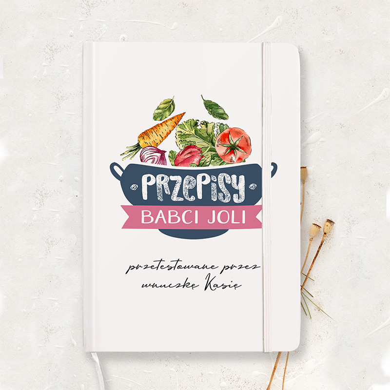 Okładka zeszytu z tytułem "Przepisy Babci Joli", na której znajduje się garnek z kolorowymi warzywami, takimi jak marchew, pomidor i sałata, oraz napisem "przetestowane przez wnuczkę Kasię".