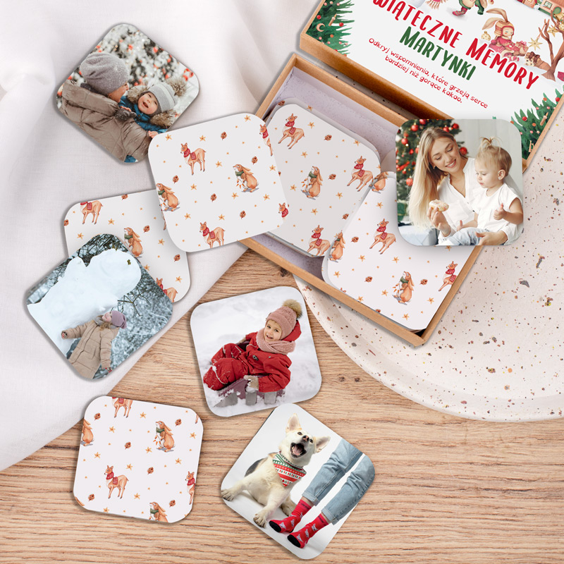 Zestaw kwadratowych podkładek pod kubki z różnymi ilustracjami i zdjęciami, w tym dziecko w czerwonym płaszczu na śniegu, pies z kolorową bandaną oraz dzieci w zimowych ubraniach, leżący obok ozdobnego pudełka na stół.
