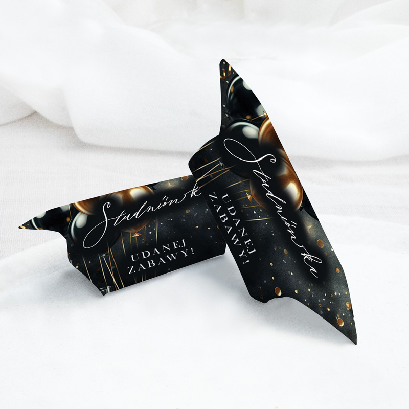 Dwa zagięte kartoniki z życzeniami w stylu eleganckim, na czarnym tle z złotymi i srebrnymi elementami dekoracyjnymi, z tekstem 'Studniówka! Udanéj Zabawy!'.