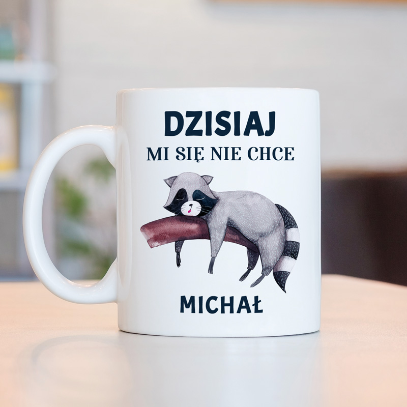 Kubek z rysunkiem leniwego szopa, leżącego na kanapie, i napisem 'DZISIAJ MI SIĘ NIE CHCE '.