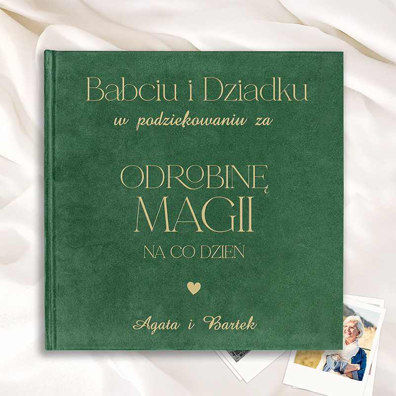 Zielona okładka albumu z napisem "Babciu i Dziadku" oraz "Odrobinę Magii na co dzień". W tle białe tkaniny i zdjęcia.