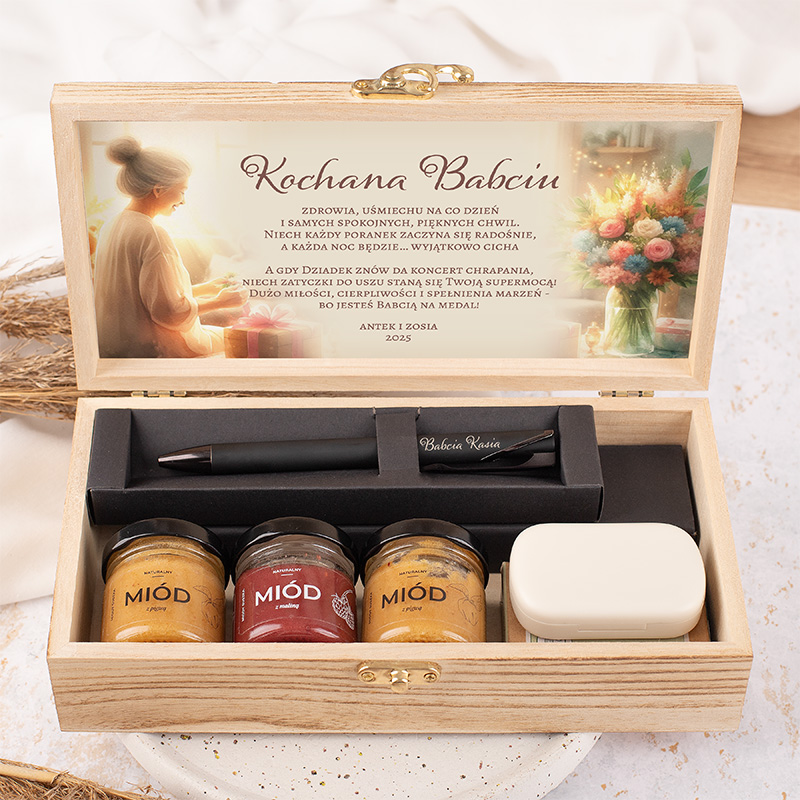 Skrzynka z napisem "Kochana Babciu", zawierająca słoiki miodu i długopis, z ilustracją kobiety w tle.