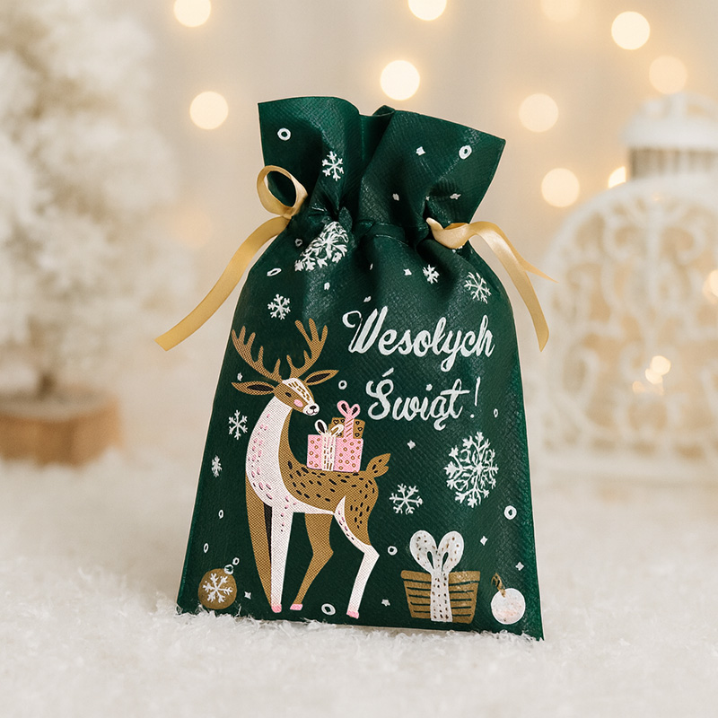 Zielona torba prezentowa z wizerunkiem renifera trzymającego małe prezenty, z napisem "Wesołych Świąt!" i zdobieniami śnieżynek oraz prezentów na tle rozmytego tła w ciepłych kolorach.