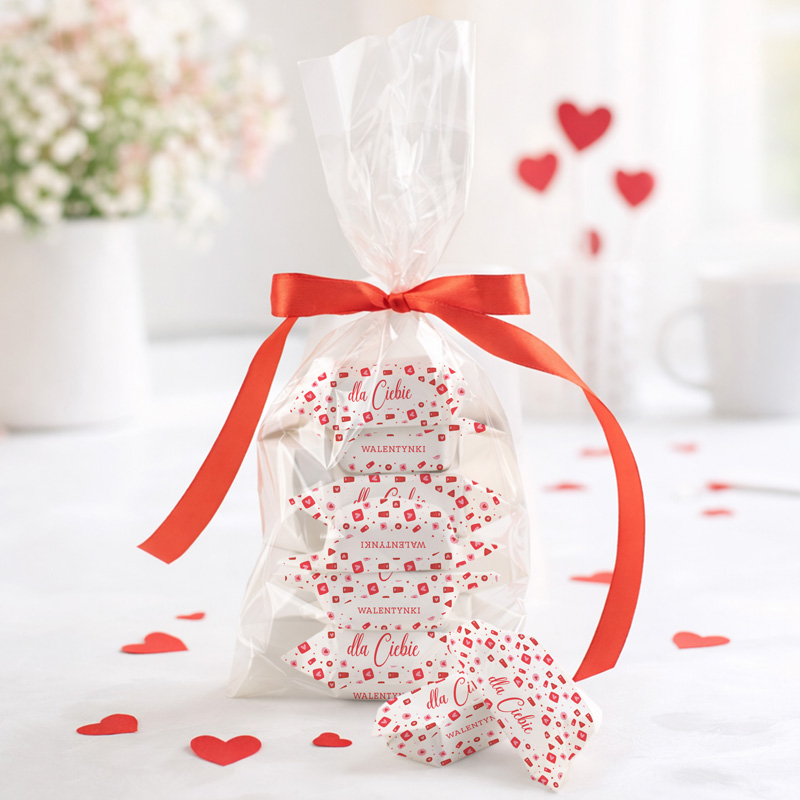 Zestaw słodkości w przezroczystej torbie z czerwoną wstążką, udekorowany serduszkami, z napisem "dla Ciebie" i "walentynki".