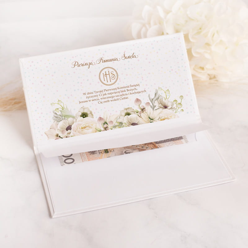 Elegancka karta z dekoracyjnym nadrukiem i napisami, położona na jasnym tle, otwarta na stronie wewnętrznej z florystycznym motywem.