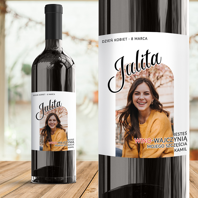Butelka wina z etykietą z imieniem "Julita" i napisem "Dzień Kobiet - 8 Marca", obok zdjęcie uśmiechniętej kobiety w żółtym swetrze.