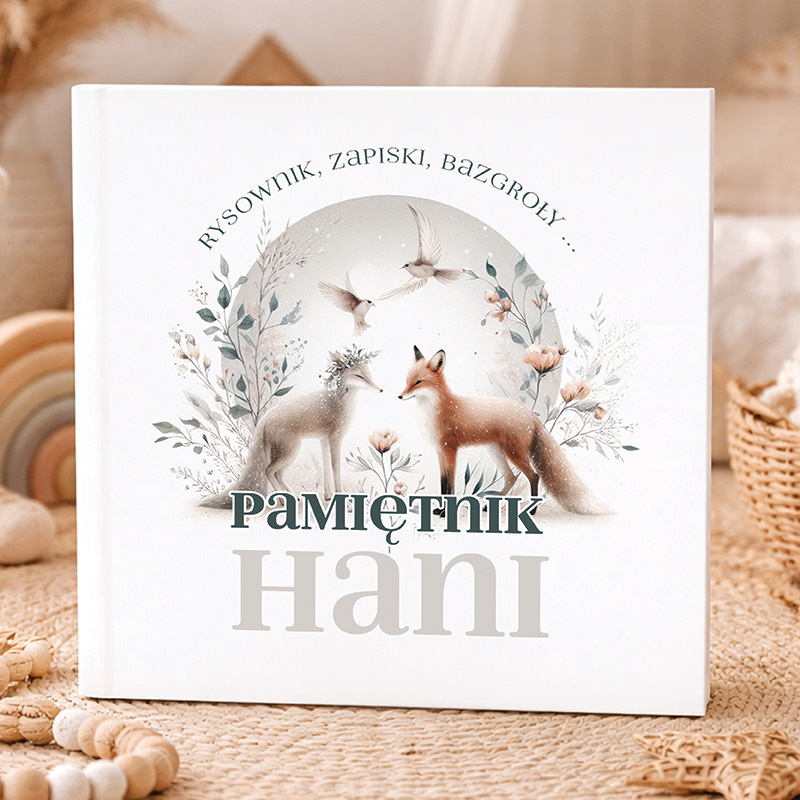 Album z ilustrowaną okładką z dwoma lisami i ptakami w tle, z tytułem "Pamiętnik Hani" i dodatkowymi dekoracjami kwiatowymi.