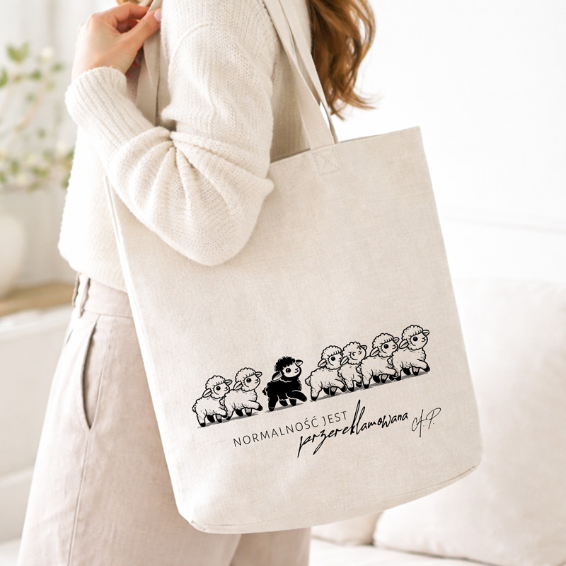 Torba na ramię w kolorze jasnym z rysunkiem owiec oraz napisem "NORMALNOŚĆ JEST PRZEREKLAMOWANA".
