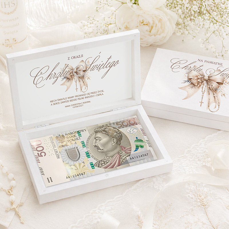 Biała, ozdobna skrzynka z banknotem 500 złotych, napisami i dekoracjami związanymi z okazją Chrzcin.