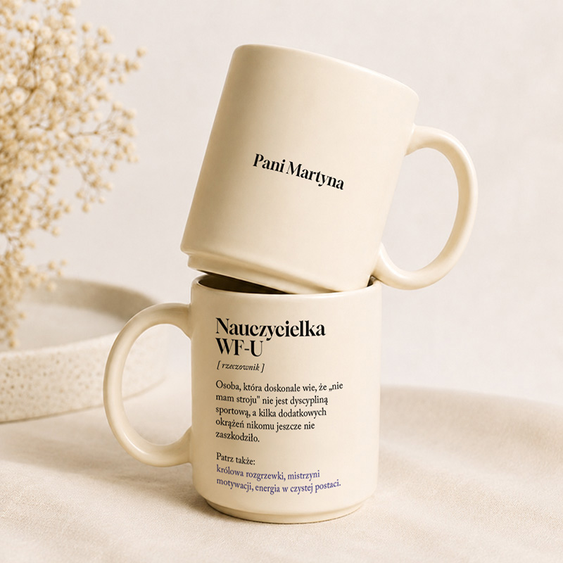 Dwie ceramiczne filiżanki ustawione jedna na drugiej. Górna ma napis "Pani", a dolna "Nauczycielka WF-U" z dodatkowymi informacjami.