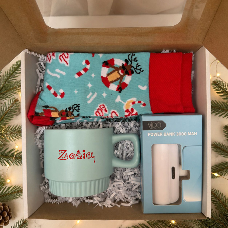 Niebieski zestaw świąteczny z kubkiem z imieniem, powerbankiem 3000 mAh i skarpetami w pudełku.