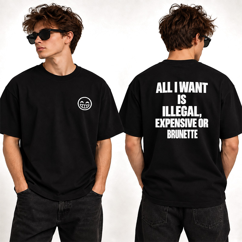 Młody mężczyzna w czarnej koszulce z uśmiechniętą buźką z przodu i napisem "ALL I WANT IS ILLEGAL, EXPENSIVE OR BRUNETTE" na plecach.