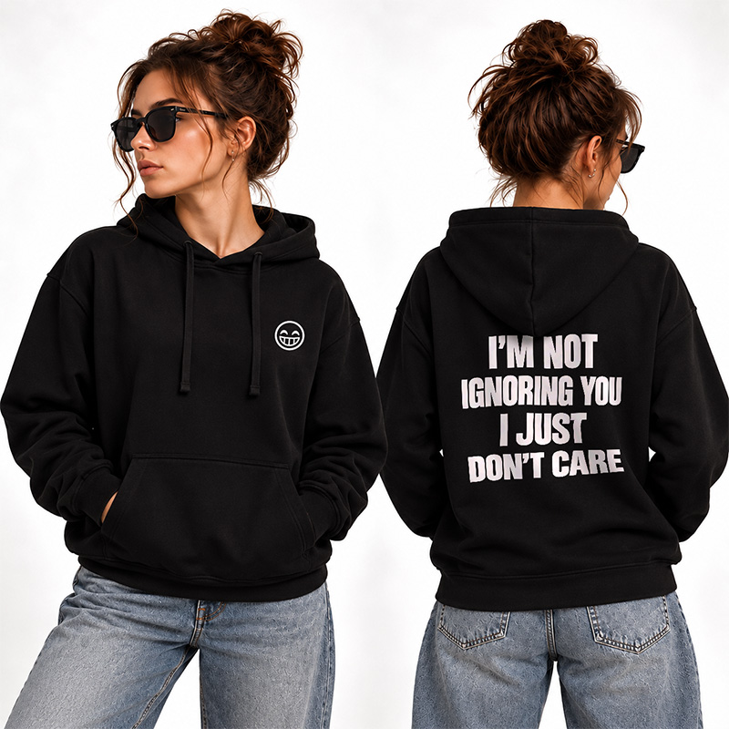 Kobieta w czarnej bluzie z kapturem i okularach przeciwsłonecznych, z napisem na plecach: "I'M NOT IGNORING YOU I JUST DON'T CARE".