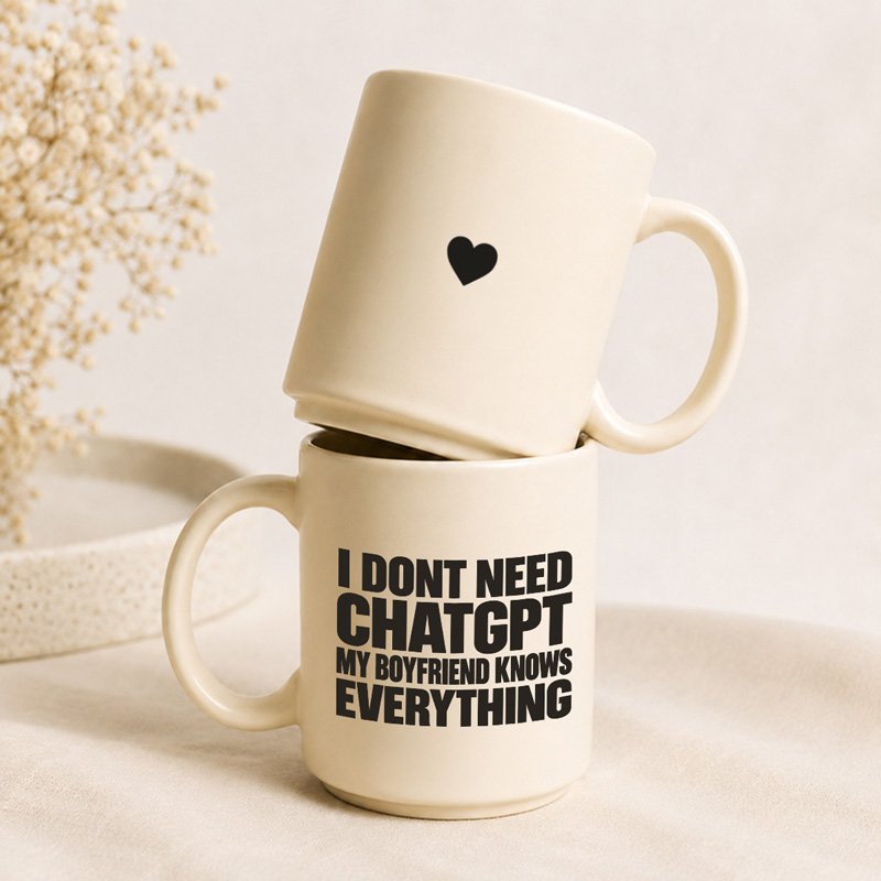 Dwa kubki ceramiczne, jeden z sercem, drugi z napisem „I DONT NEED CHATGPT MY BOYFRIEND KNOWS EVERYTHING”.